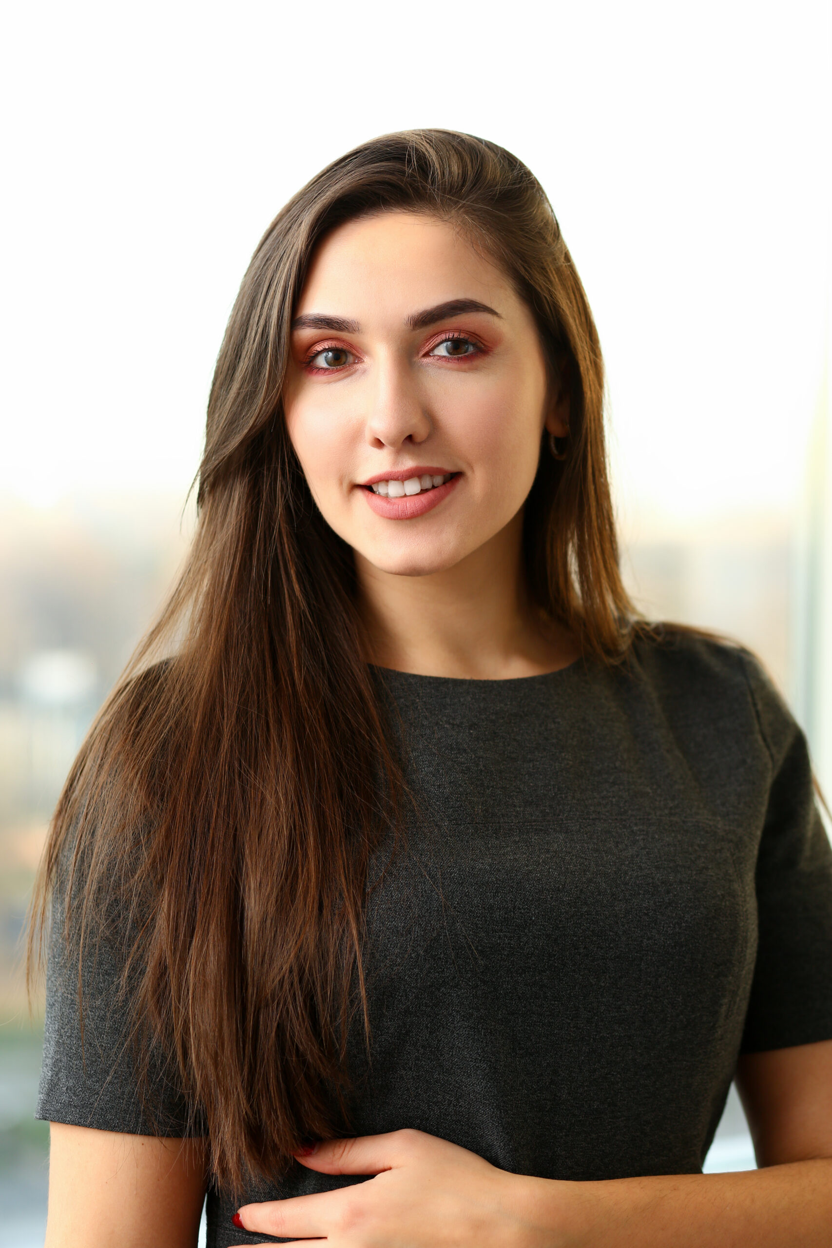 Beautiful european woman portrait. Worth office background and smiling beauty fashion style curly hair with white strands view of the eye in the camera